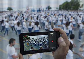 Pessoa filma multidão com smartphone